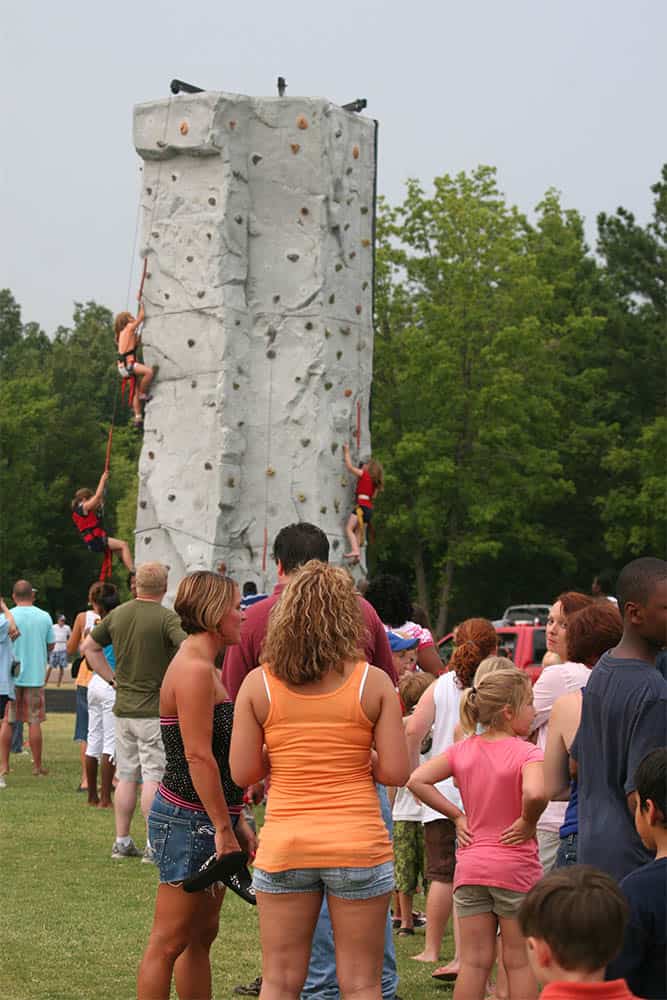 A Line Waiting to Utilize an Outdoor Rock Climbing Wall