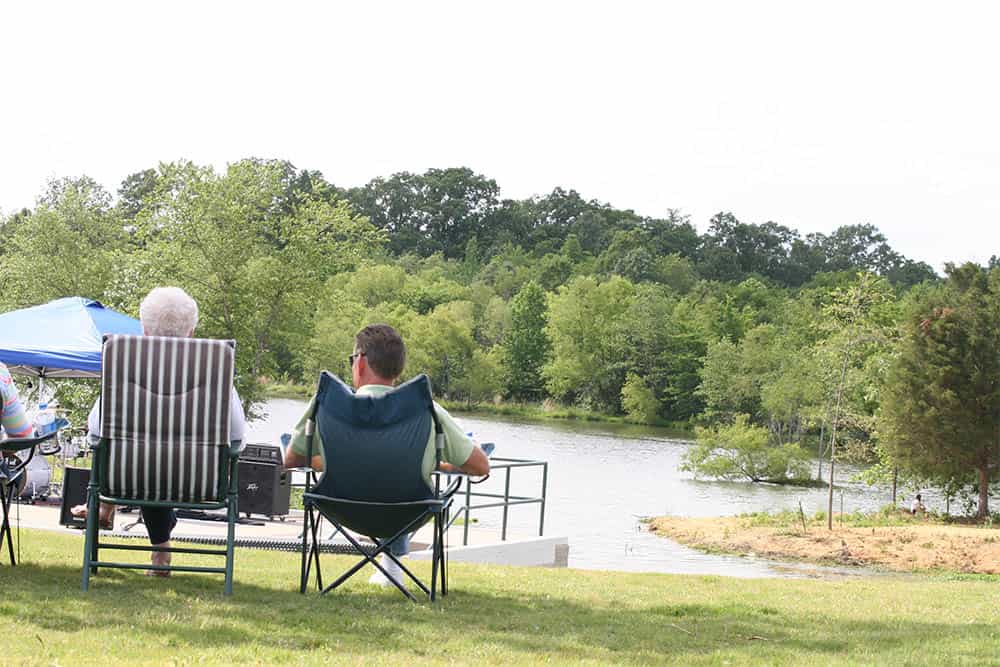 Couple Sitting in Lawn Chairs by a Lake
